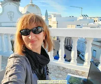 Alonga Travel the author smiles behind her laptop in her mobile rooftop office in Portugal over
