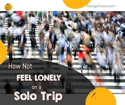 a crowd of people crossing a street & a custom sign: 'How not to feel lonely on solo trip'