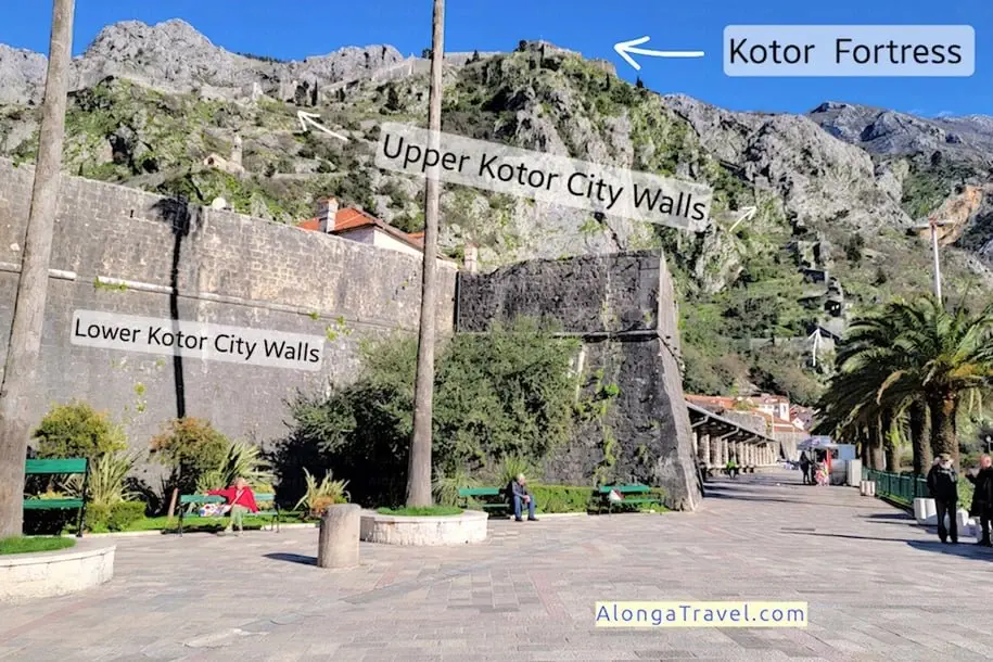 City wall in Old town Kotor with fortifications seen hanging on a steep 🗻 with a castle on the top