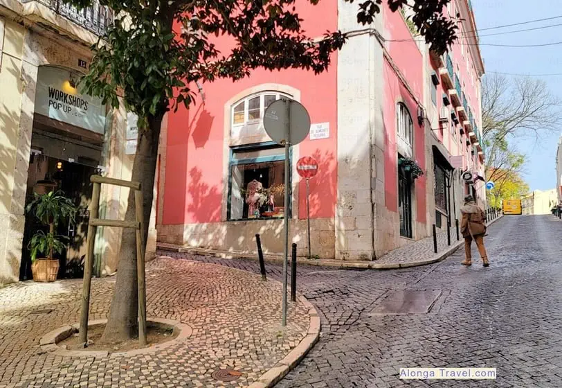 beautifully sunlit pink house and slanted cobblestone paved street