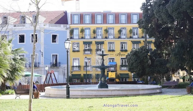 Sophisticated colorful houses by a park on Alegria Square with a fountain