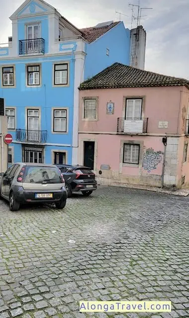 Blue and pink faded houses on old cobbled street