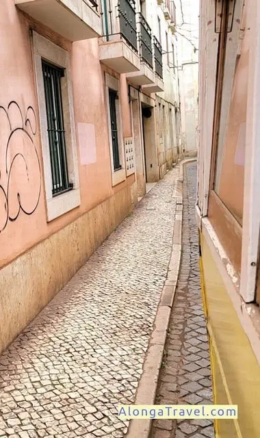 Pink old houses on very narrow street in Alfama