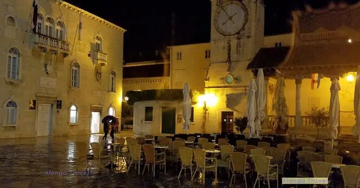 Cozy ambience of yellow medieval buildings at night around a light up old square