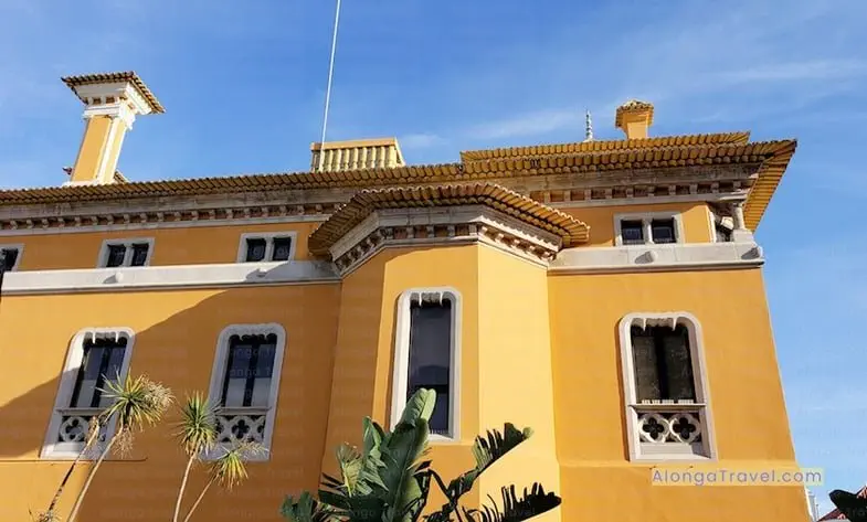 White quatrefoils or four-petaled flowers on a yellow building in Spain