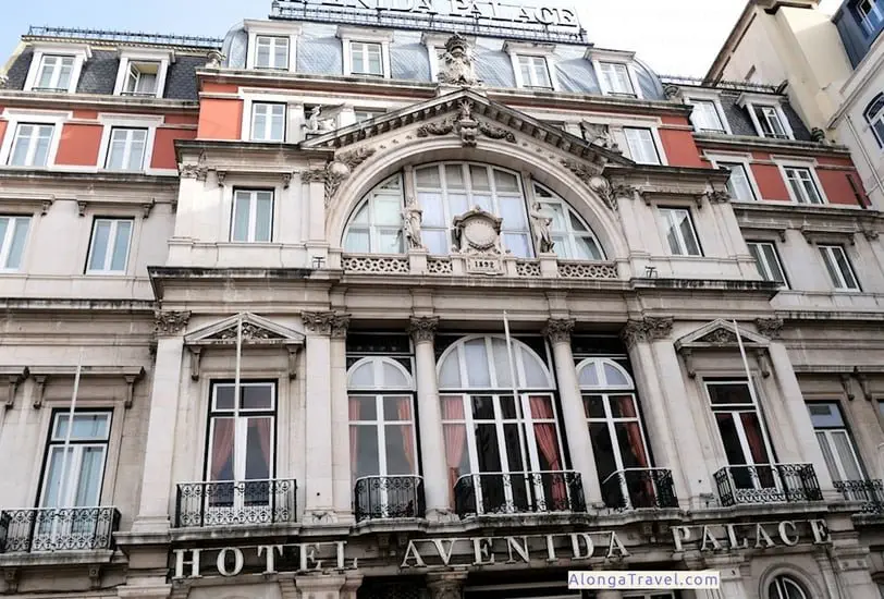 Gray Pombalin style building decorated with white columns, statues and plaster