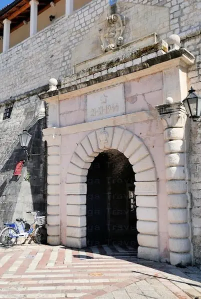 Pink with a round arch Sea Gates to enter fortified medieval walls to explore Old town Kotor