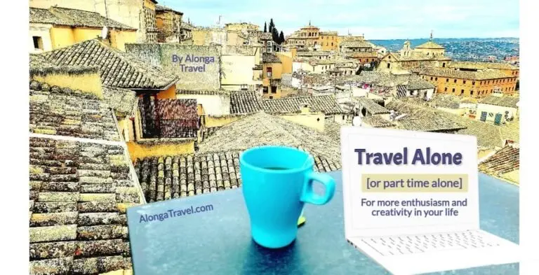 A solo cup of tee on a table on rooftoop terrace, overlooking medieval roofs, & a sign: 'Travel solo for my creativity'