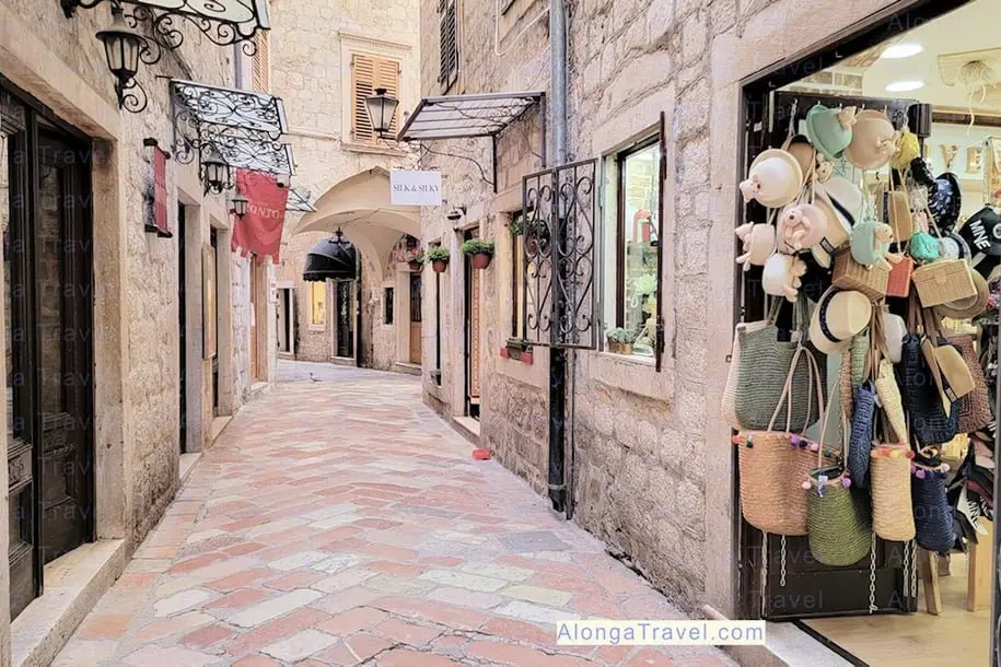 A door with souvenirs hanging on it on a narrow cobblestone street in Old town Kotor