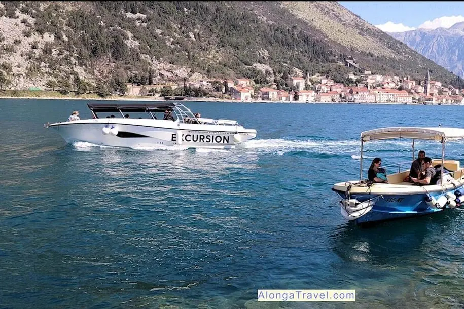 2 boats I saw on Kotor bay in front of a tall â›° during my boat tour & sign: 'excursion' on one boat
