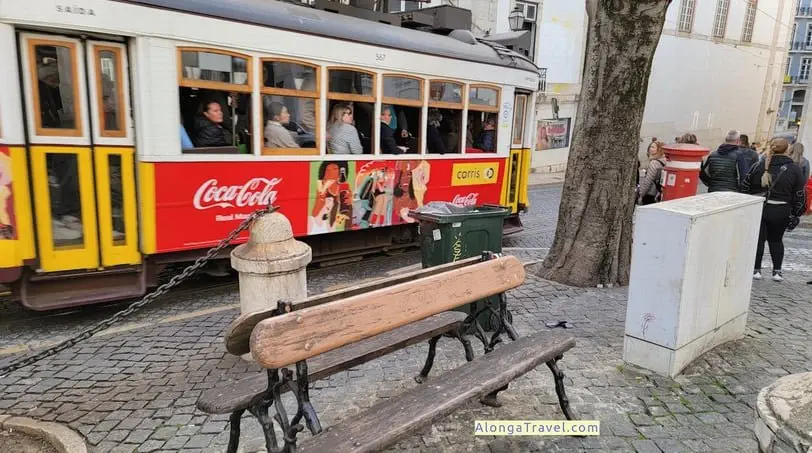 A crowded tram 28 car passes in popular Alfama district of Lisbon