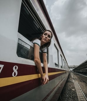 A solo female traveler looking out from a train window