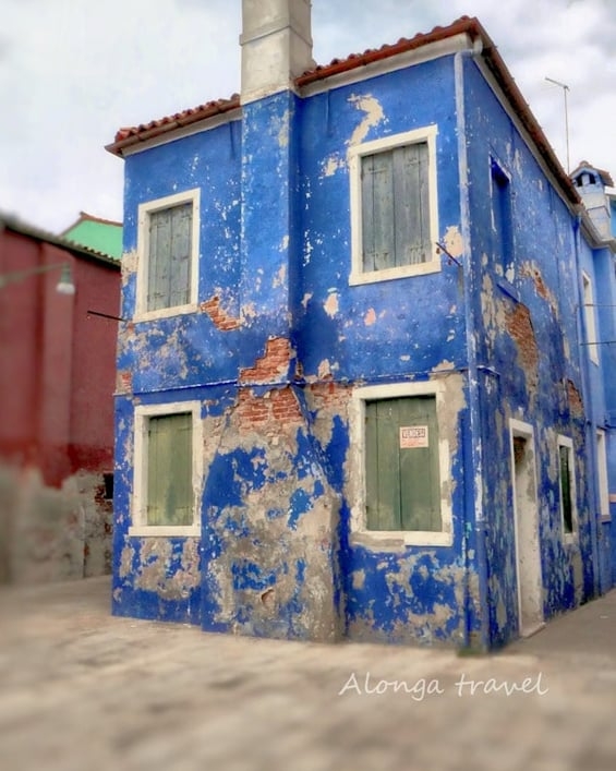 Colorful blue older building in Burano, Venice - the best destination in Europewith peeled paint