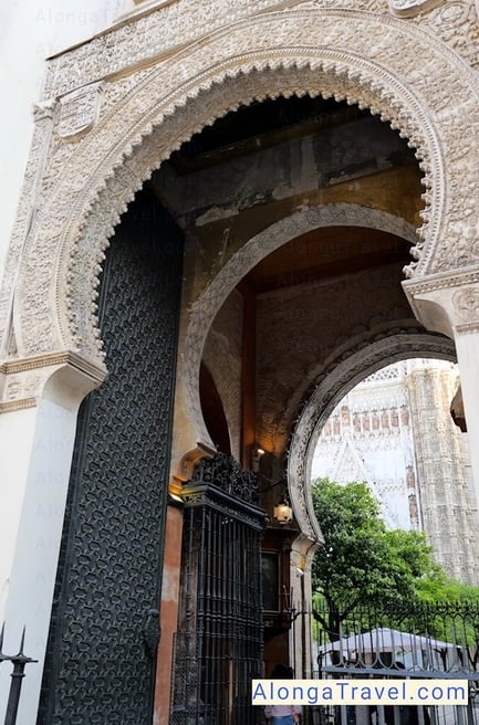 Horseshow shaped beautiful beige colored side entrance to Seville Cathedral