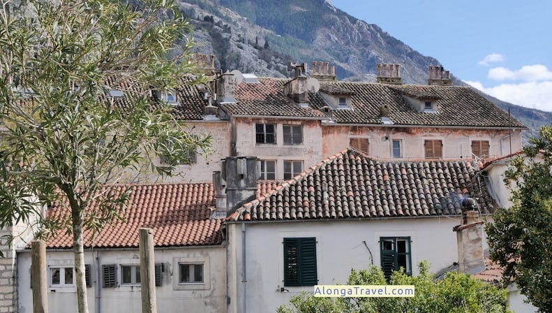 picturesque houses with mountains in the background as seen from city walls in Kotor