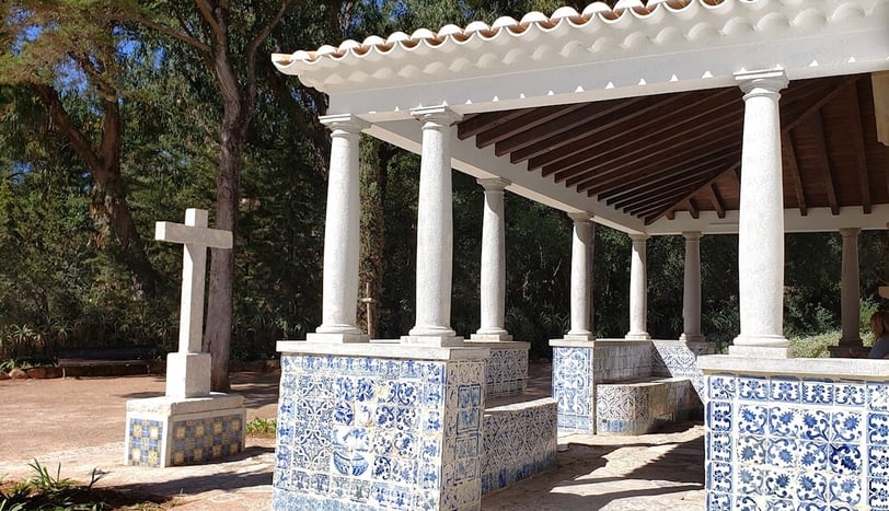 A cross & a patio decorated with blue & white tiles in Cascais