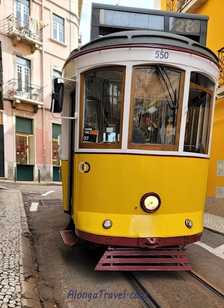 Vintage yellow tram 28 on a narrow street of Lisbon
