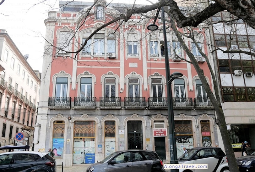 White decorative moldings over the door and windows of a pink Pombaline style building
