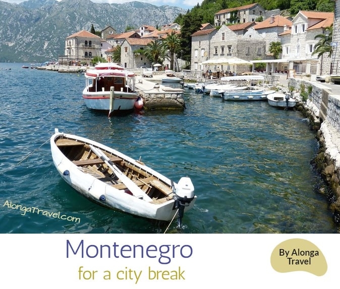 Boats floating in front of an old town & a custom sign: 'Montenegro for a city break'